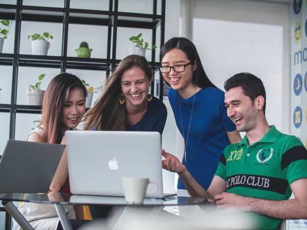 Four people sharing a laptop