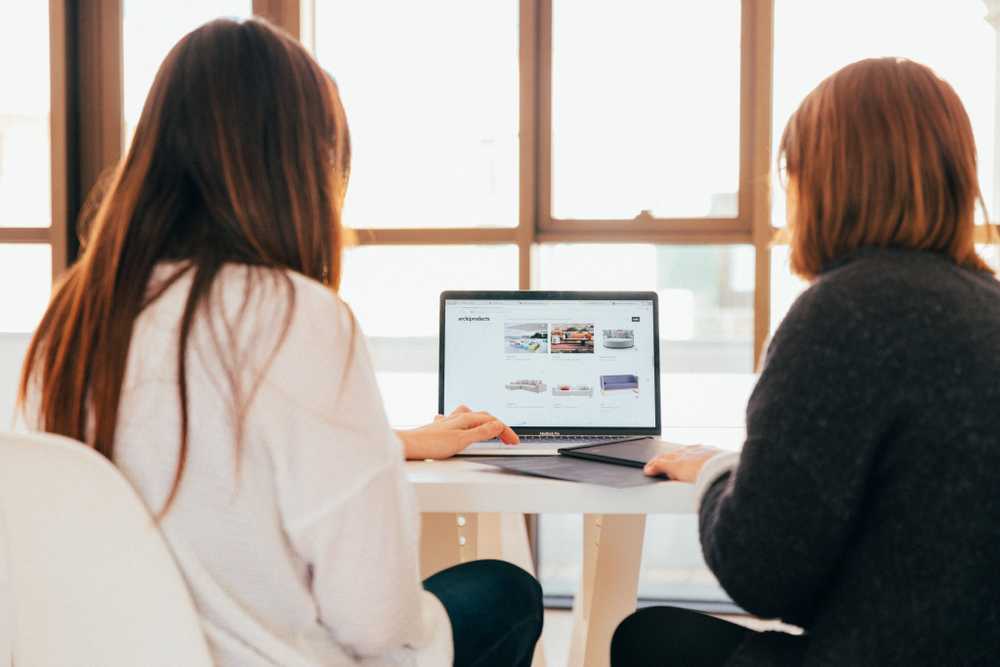 Two women sharing a laptop