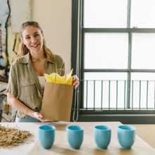 Business woman packaging mugs
